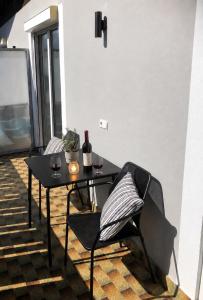 a black table with two chairs and wine glasses at Apartment Torggl Alpenblick in Coldrano