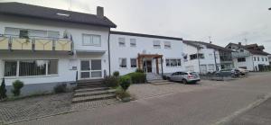 a white house with a car parked in front of it at Gasthaus Mösle in Oberreute