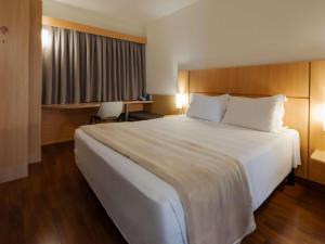 a large white bed in a hotel room at Ibis Florianopolis in Florianópolis