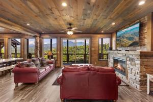 a living room with couches and a fireplace at Splash N Heavenly Views in Gatlinburg