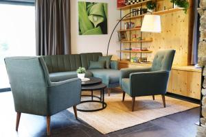 a living room with two chairs and a couch at Wellness Chalupy LETOKRUHY in Jeseník