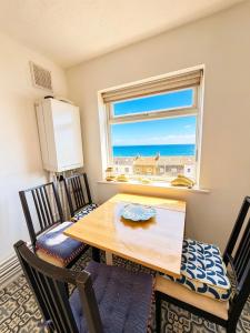 a dining room with a table and chairs and a window at Captain Normans Sea view in Hollington