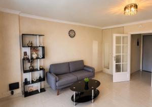 a living room with a couch and a table at Vue Panoramique Vence Balcon & Calme in Vence +1 photo