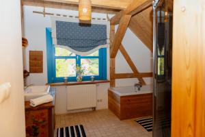 a bathroom with a window and a tub and a sink at Siedlisko Pod Strzechą in Wólka +38 photos
