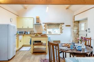 a kitchen and dining room with a table and a refrigerator at 1 Bed in Stoke Abbott oc-35012 in Burstock +19 photos