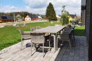 a table and chairs on a patio with a field at Wellness Chalupy LETOKRUHY in Jeseník