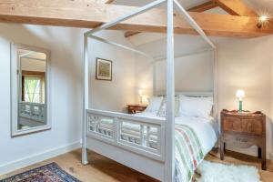 a bedroom with a white canopy bed with a mirror at 1 Bed in Stoke Abbott oc-35012 in Burstock