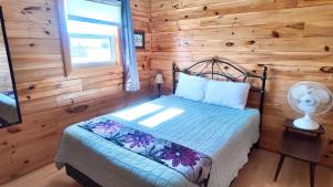 a bedroom with a bed in a log cabin at Blue Spruces Cottages in Hampton 