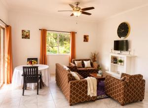 a living room with two couches and a table at Blue Sky Apartment in Soufrière