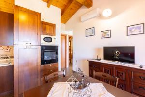 a kitchen with wooden cabinets and a dining table at Dimora Cala-Vista in Torre Dei Corsari