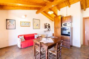 a living room with a red couch and a table at Dimora Cala-Vista in Torre Dei Corsari