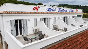 a white building with chairs and tables on a roof at Vesta Motel in Vieste