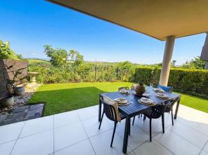 a table and chairs on a patio with a view of a yard at Ballito Zimbali Wedge in Ballito