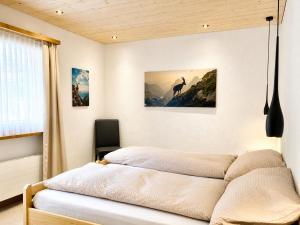 a bedroom with a bed with a picture on the wall at Chasa ARLU in Samnaun +17 photos
