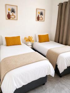 two beds sitting next to each other in a room at 60 On Kosmos in Bellville South