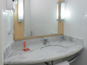 a bathroom with a sink and a mirror at ibis Aracaju in Aracaju