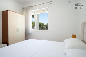 a white bedroom with a bed and a window at Joni's Small Condo in Golem