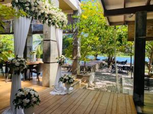 a pavilion with white curtains and flowers in vases at River Tree Bolgoda in Panadura