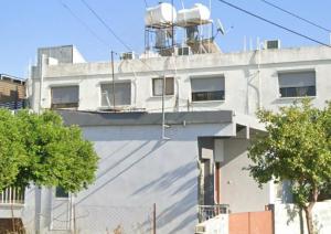 a white building with a water tower on top of it at Xrysanthis Kaouris in Limassol