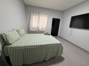 a bedroom with a bed and a television in it at Lotus in Gurupi