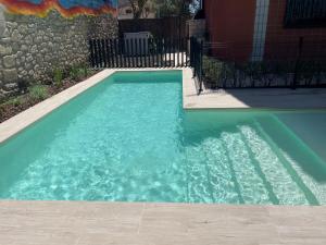 a swimming pool with blue water in a yard at Casa Zacarias - Bonitas vistas en La Rioja in Herramélluri