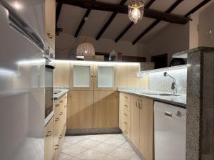 a kitchen with wooden cabinets and a sink at A Casita do Ferreiro in Sober