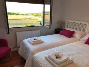 a bedroom with two beds with towels and a window at Casa Zacarias - Bonitas vistas en La Rioja in Herramélluri +22 photos