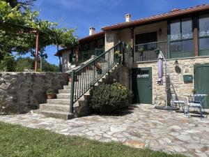 a house with a green door and a patio at A Casita do Ferreiro in Sober