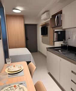 a small apartment with a kitchen and a table in a room at 818 - Standard Premium in Uberlândia