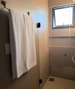 a bathroom with a towel hanging on a shower door at 818 - Standard Premium in Uberlândia +15 photos