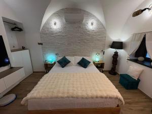 a bedroom with a large bed and a brick wall at Nena Maleni in Tovo San Giacomo +49 photos