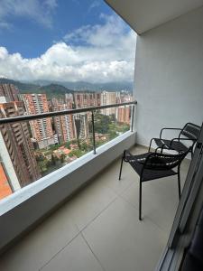 a balcony with two chairs and a view of a city at Atardeceres de Sabaneta in Sabaneta