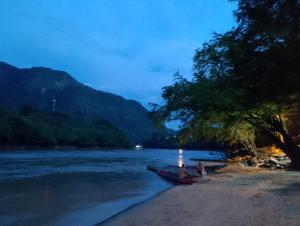 a group of people standing on the shore of a river at Remanso del Río in Honda