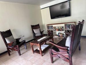 a living room with three chairs and a flat screen tv at Apartamento Amoblado Refugio Mérida in Mérida