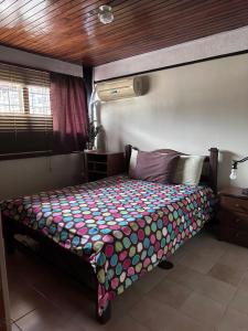 a bedroom with a bed with a colorful comforter at Apartamento Amoblado Refugio Mérida in Mérida