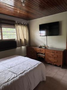 a bedroom with a bed and a dresser with a flat screen tv at Apartamento Amoblado Refugio Mérida in Mérida +2 photos