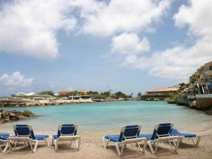 um grupo de cadeiras sentadas numa praia em Gorgeous Apartment in Willemstad with Pool em Jan Thiel