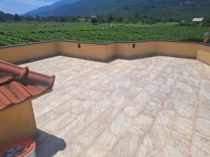 a patio with a view of a field and mountains at Apartman Dar Bošković Klasik in Danilovgrad +5 photos
