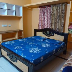 a bed in a room with a blue blanket on it at Jyothi swaroop bhakta nivas in Tirupati