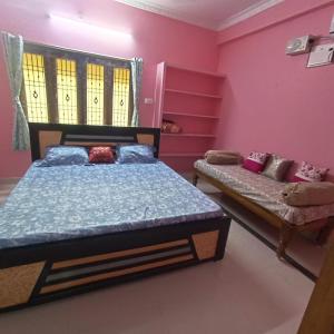 two beds in a room with pink walls at Jyothi swaroop bhakta nivas in Tirupati