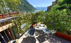 a table and chairs on a balcony with a view at NEW Larioview suites in Argegno