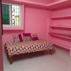a room with a pink wall with a bench in it at Jyothi swaroop bhakta nivas in Tirupati