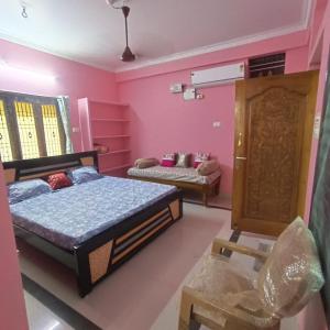 a bedroom with two beds in a room with pink walls at Jyothi swaroop bhakta nivas in Tirupati