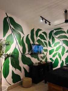 a room with a wall with a mural of leaves at Oak & olive stays in Tezpur +10 photos