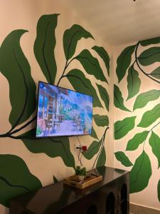 a living room with a wall mural of leaves at Oak & olive stays in Tezpur