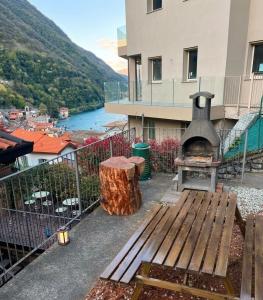 a patio with a bench and a tree stump and a stove at NEW Larioview suites in Argegno
