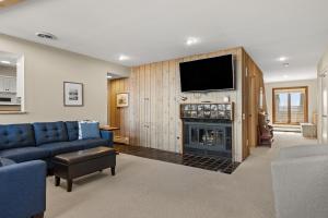 a living room with a blue couch and a fireplace at Ocasa Vista in Boyne City