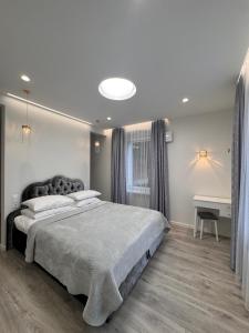 a bedroom with a large bed and a desk at Centro Apartamentai in Plungė