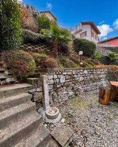 a stone retaining wall and stairs in front of a house at NEW Larioview suites in Argegno