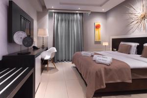 a hotel room with a large bed and a desk at Hotel Rastoni - Helvetia in Platamonas